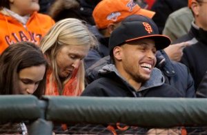 Golden State Warriors guard Stephen Curry laughs while being introduced during the second inning of baseball game between the San Francisco Giants and the Atlanta Braves on Friday, May 29, 2015, in San Francisco. (AP Photo/Eric Risberg)
